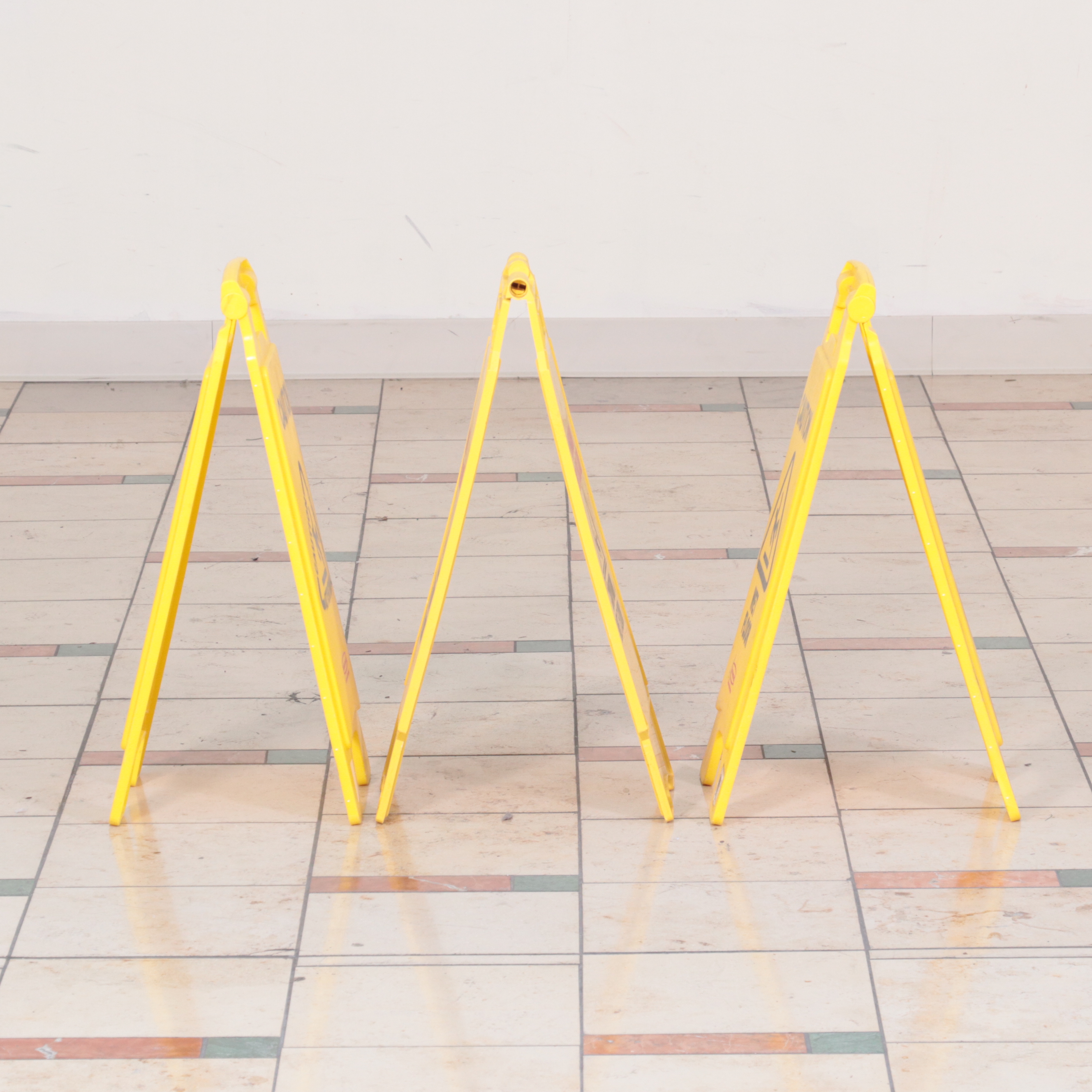 Six Rubbermaid Industrial Wheeled Mop Buckets With Three "Caution" Signs