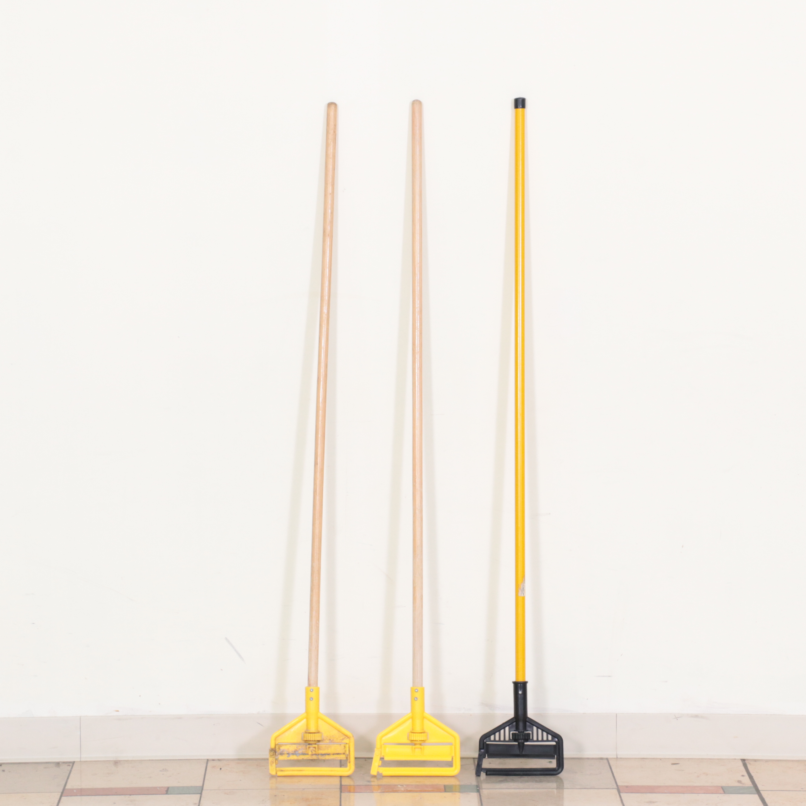 Six Rubbermaid Industrial Wheeled Mop Buckets With Three "Caution" Signs