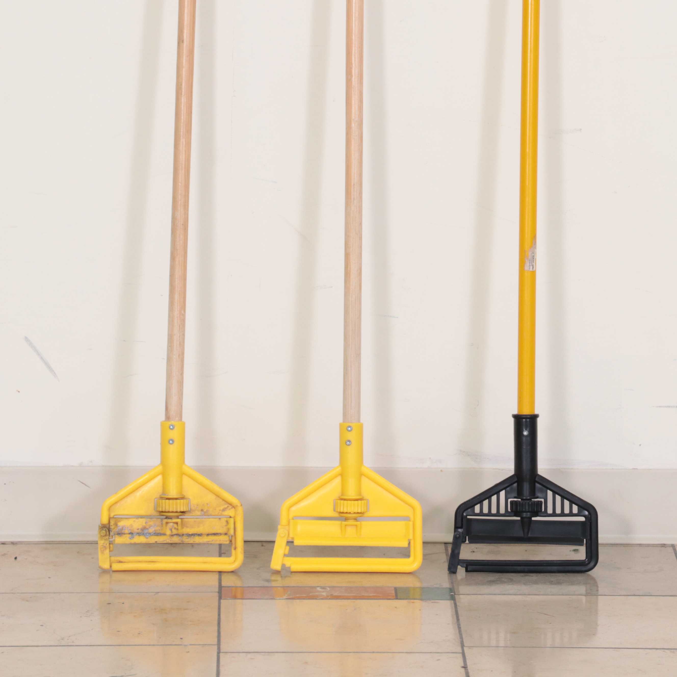 Six Rubbermaid Industrial Wheeled Mop Buckets With Three "Caution" Signs