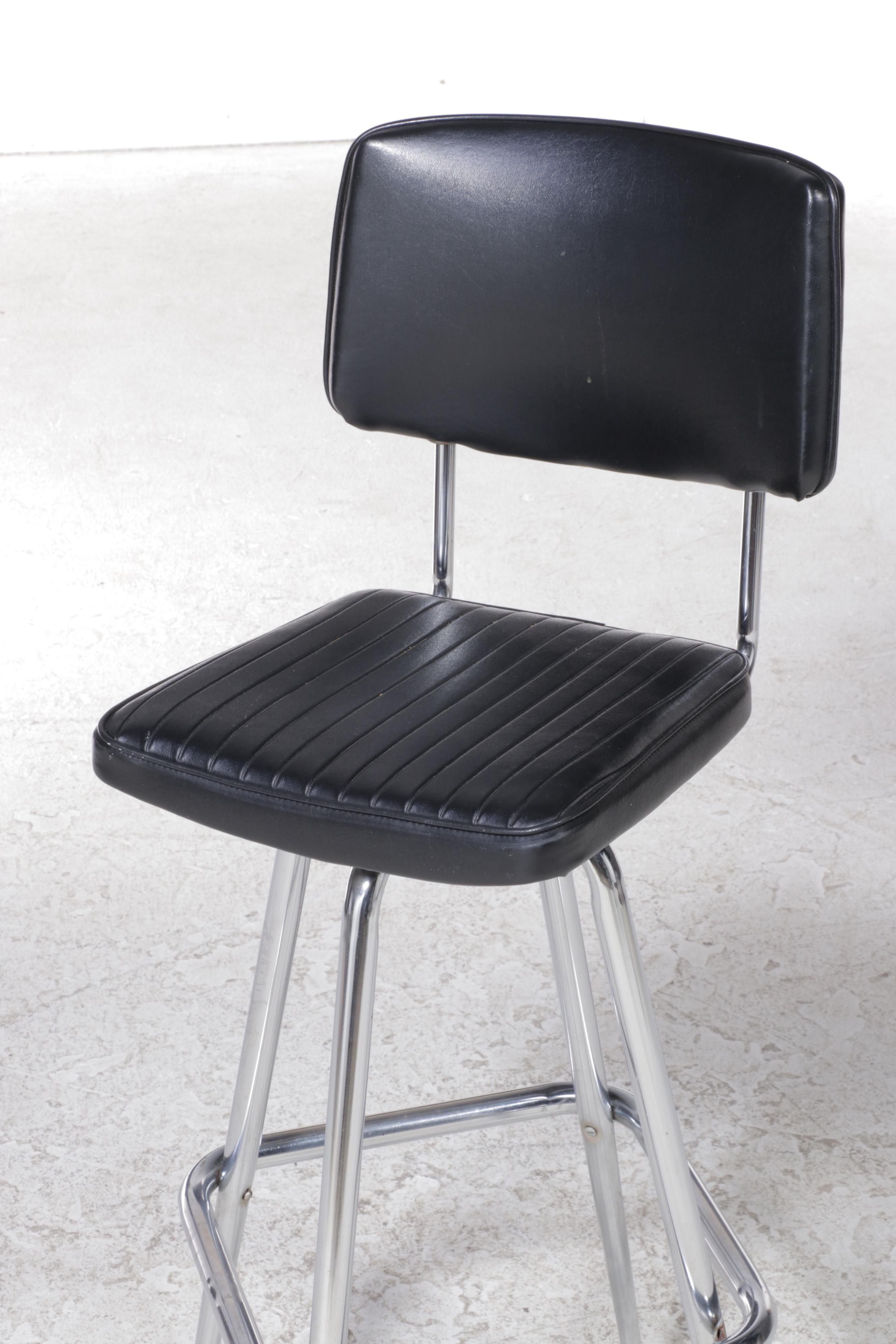 Four Chromcraft Modernist Chromed Steel and Black Vinyl Swivel Bar Stools