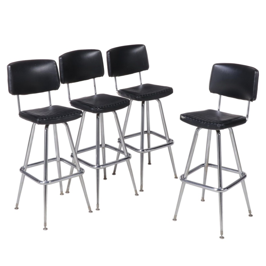 Four Chromcraft Modernist Chromed Steel and Black Vinyl Swivel Bar Stools