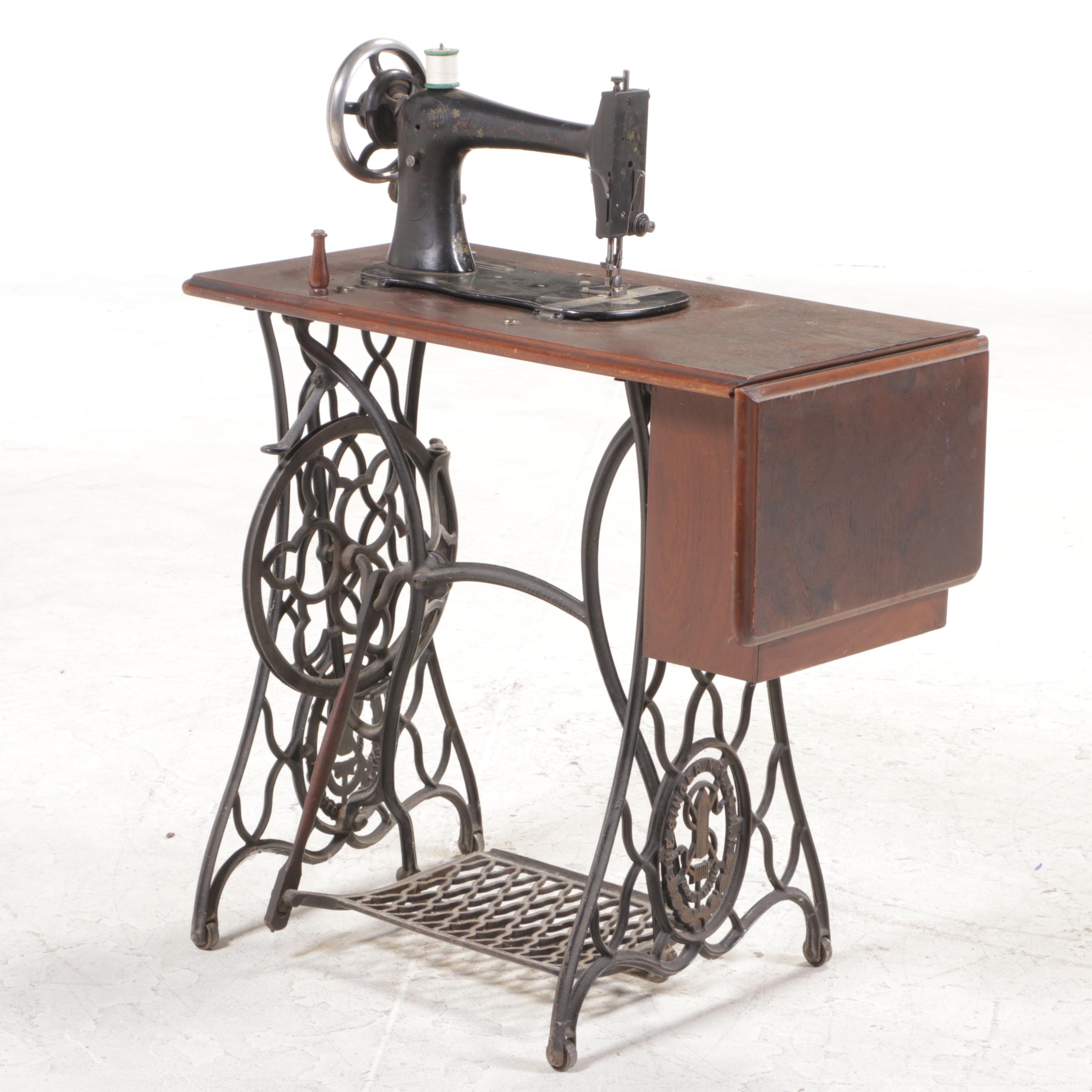 The Singer Mfg. Co. Walnut and Cast Iron Treadle-Base Sewing Machine