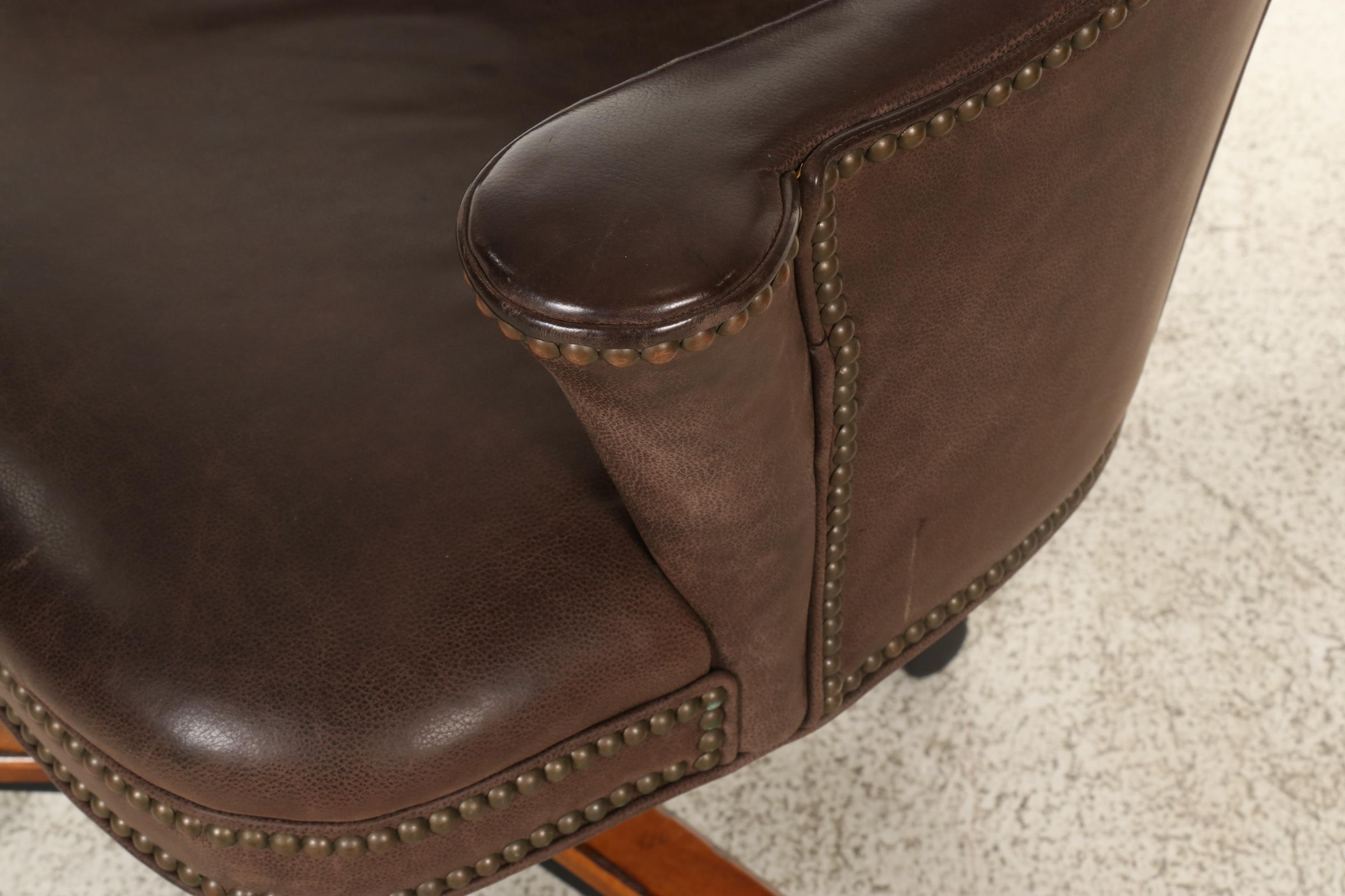 Pair of Brass-Tacked and Aged Leather Upholstered Adjustable Swivel Chairs
