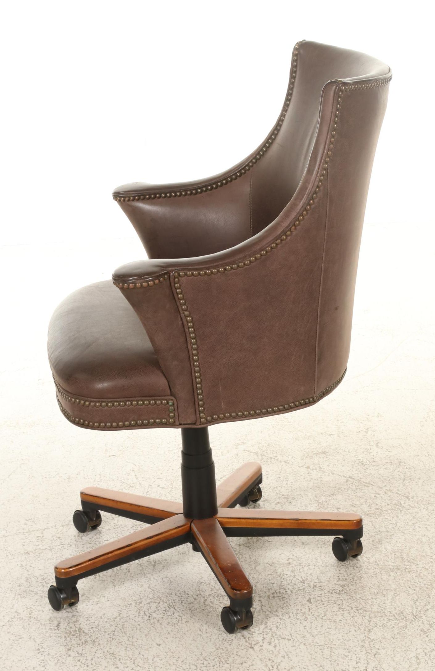 Pair of Brass-Tacked and Aged Leather Upholstered Adjustable Swivel Chairs