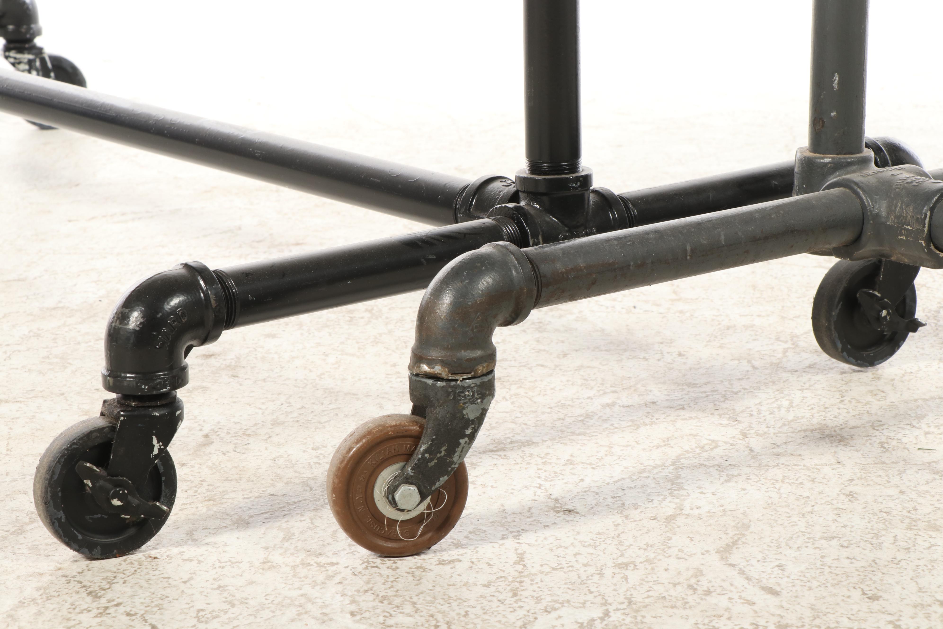 Three Black Iron Pipe Clothes Racks on Wheels