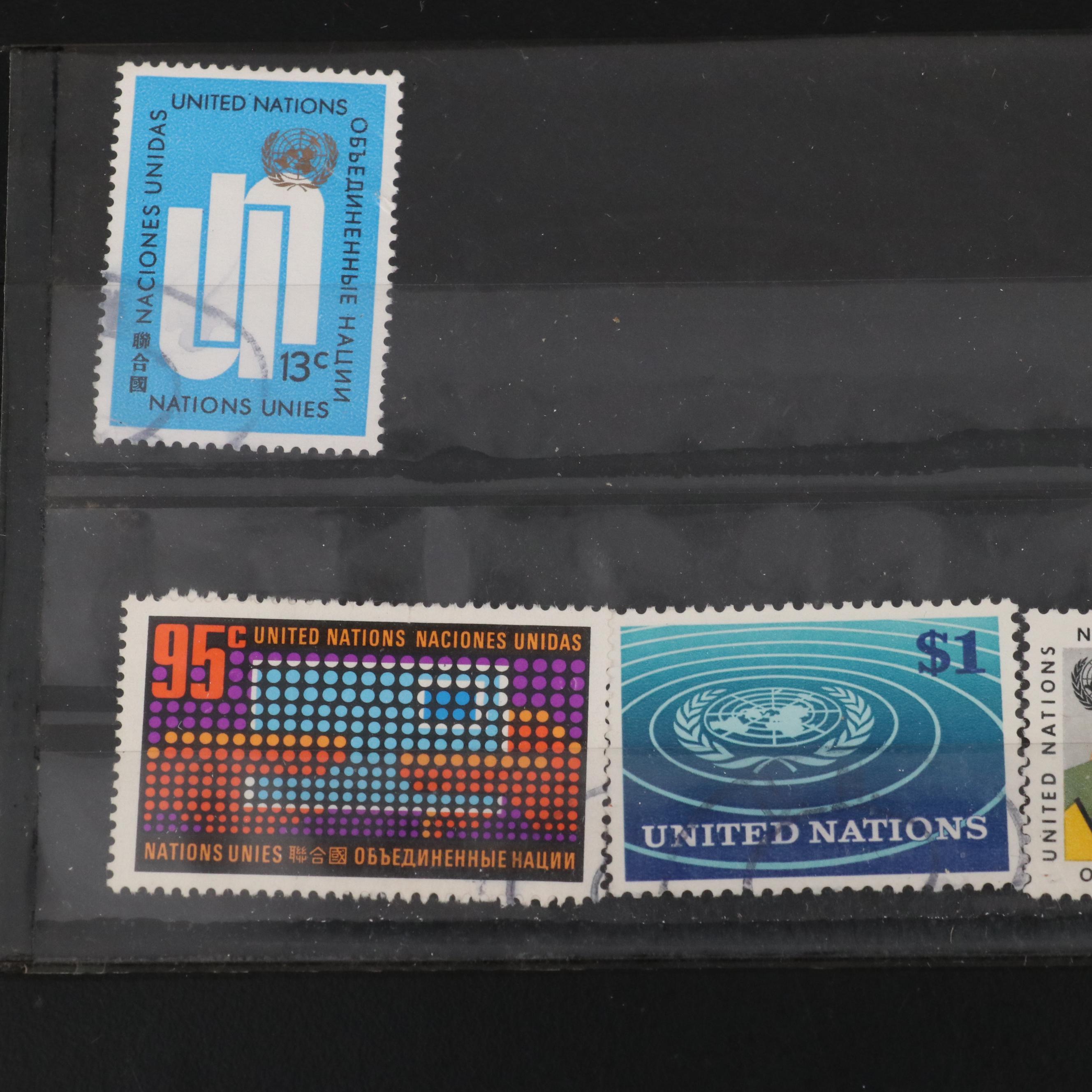 Assortment of World and U.S. Postage Stamps, Price Guide, and Binder