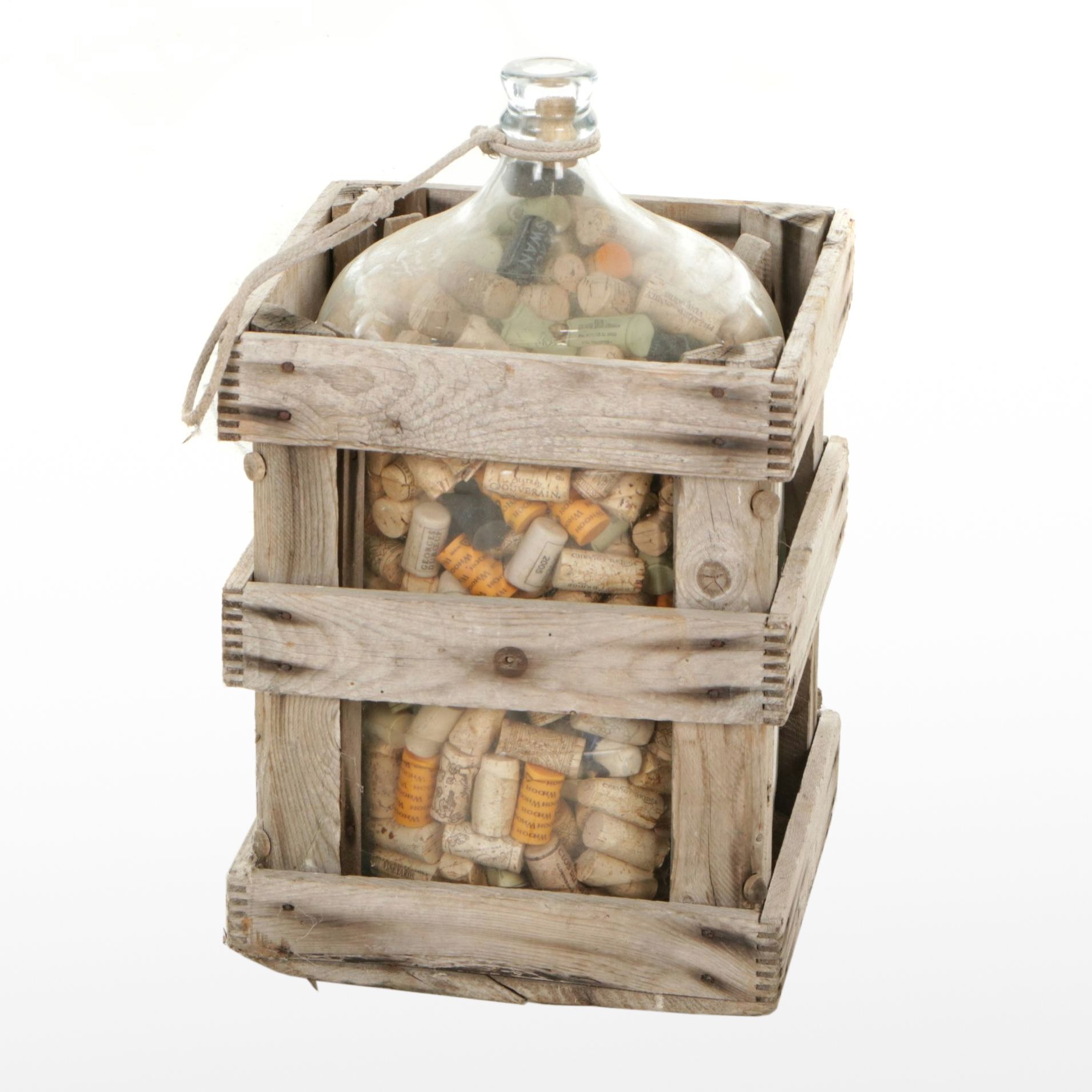 Glass Carboy Bottle Filled with Wine Corks in Distressed Wooden Crate