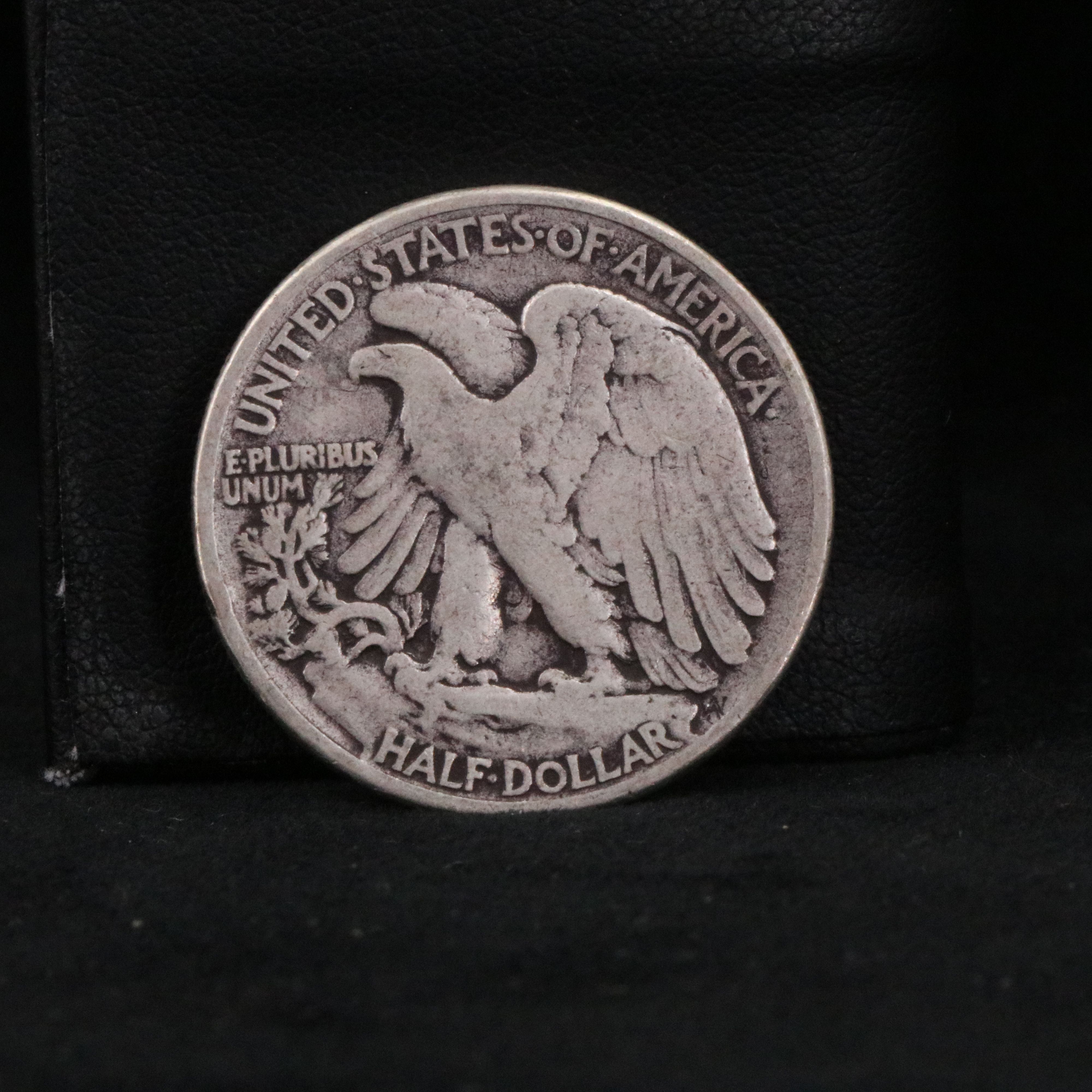 Twenty Walking Liberty half dollars and two Peace dollars