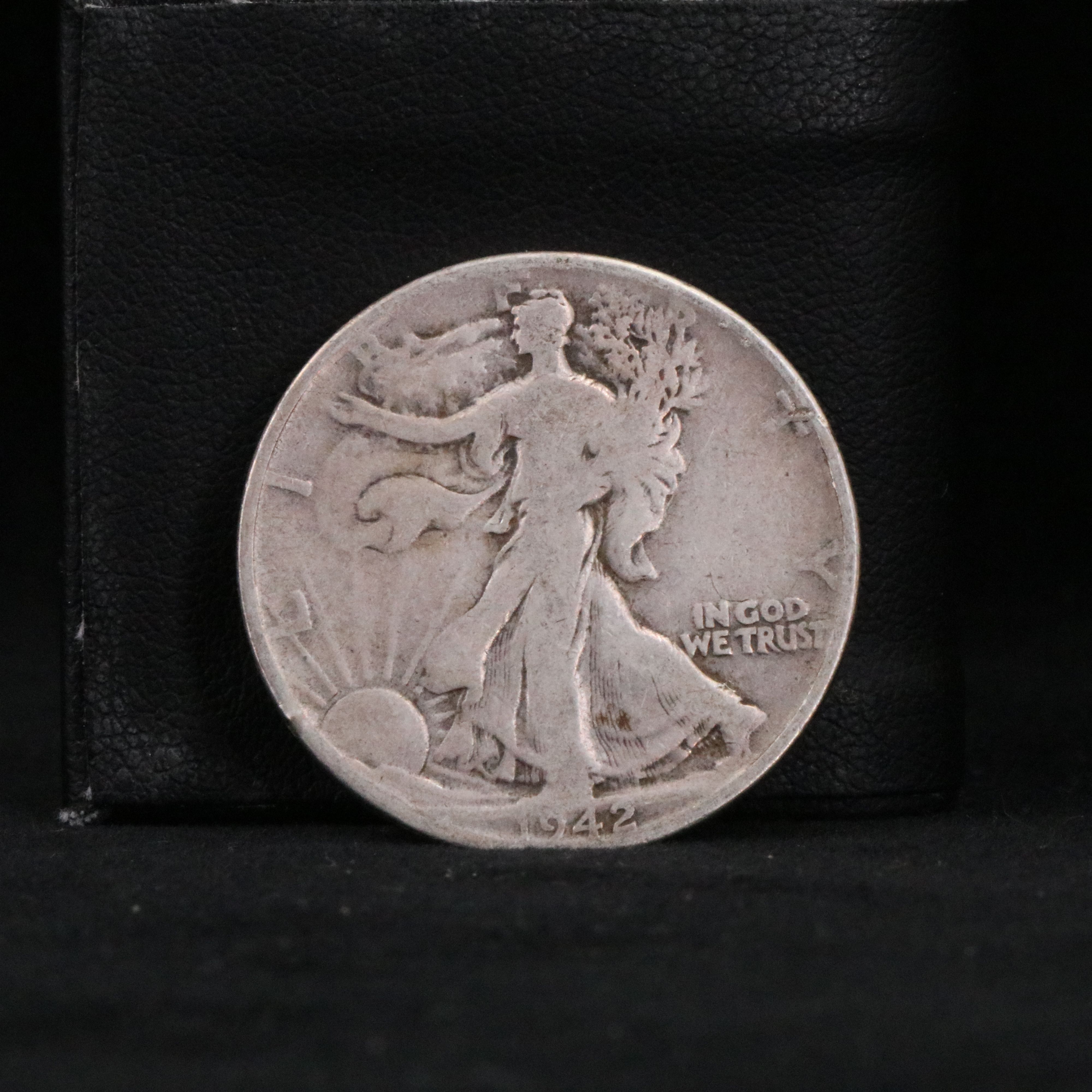 Twenty Walking Liberty half dollars and two Peace dollars