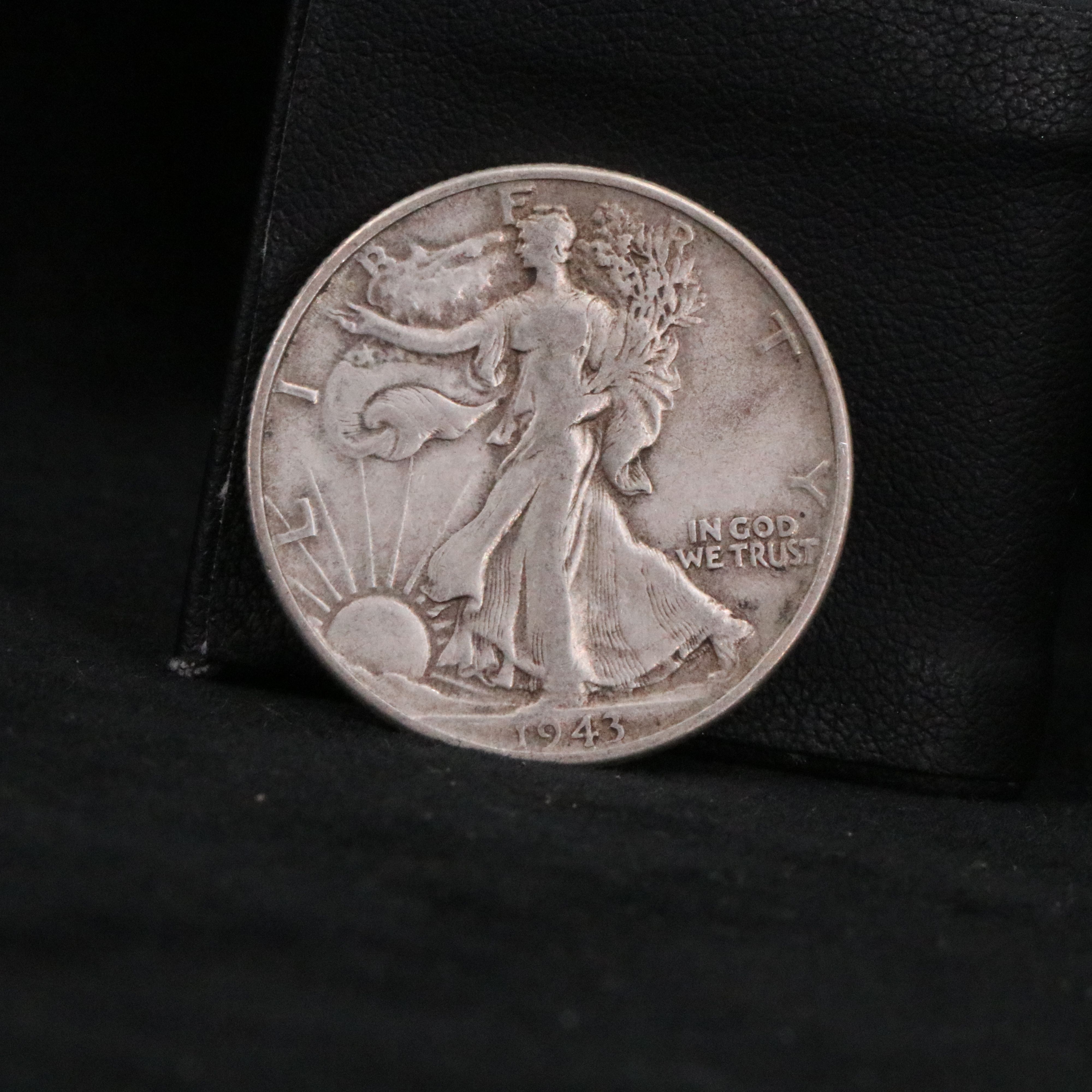 Twenty Walking Liberty half dollars and two Peace dollars