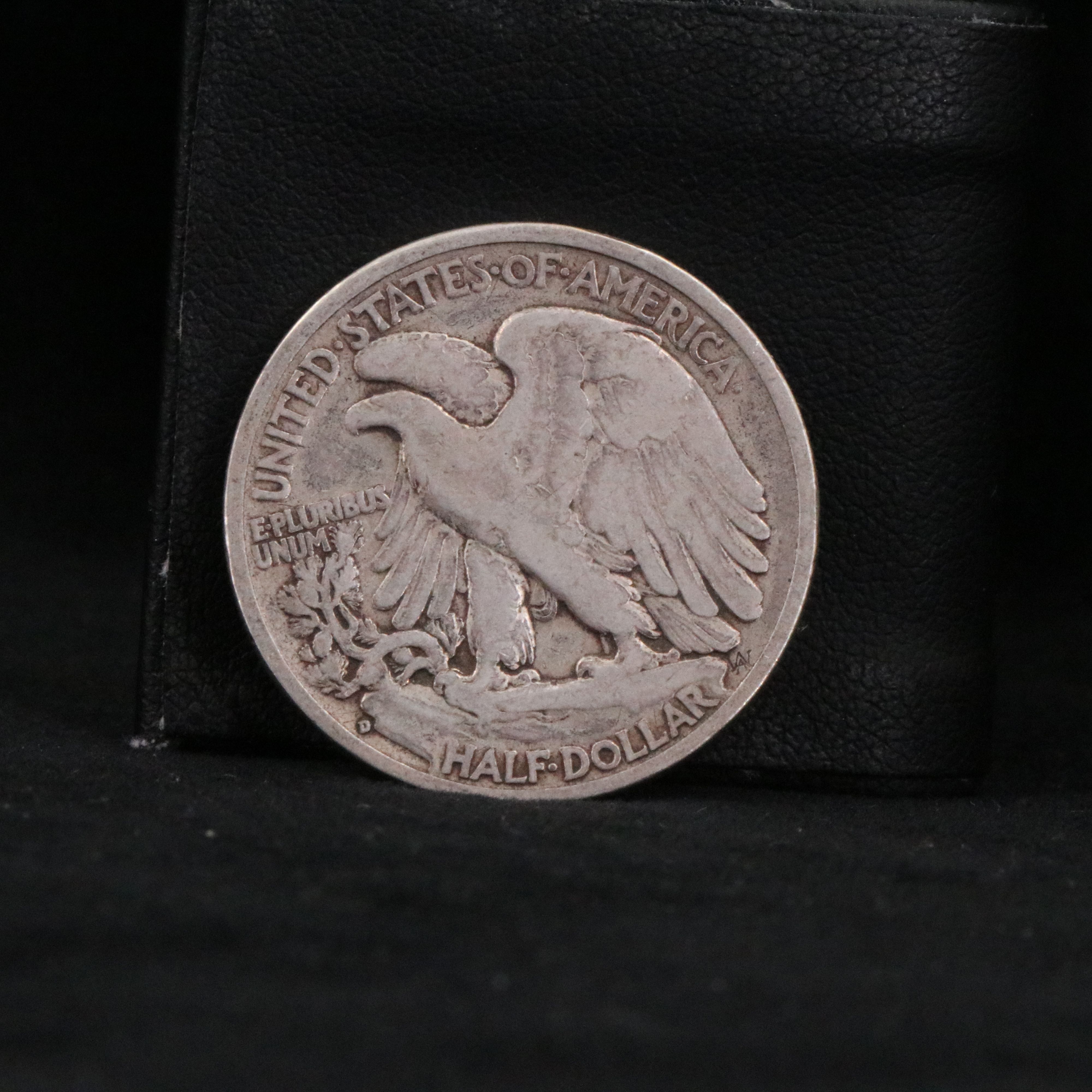 Twenty Walking Liberty half dollars and two Peace dollars