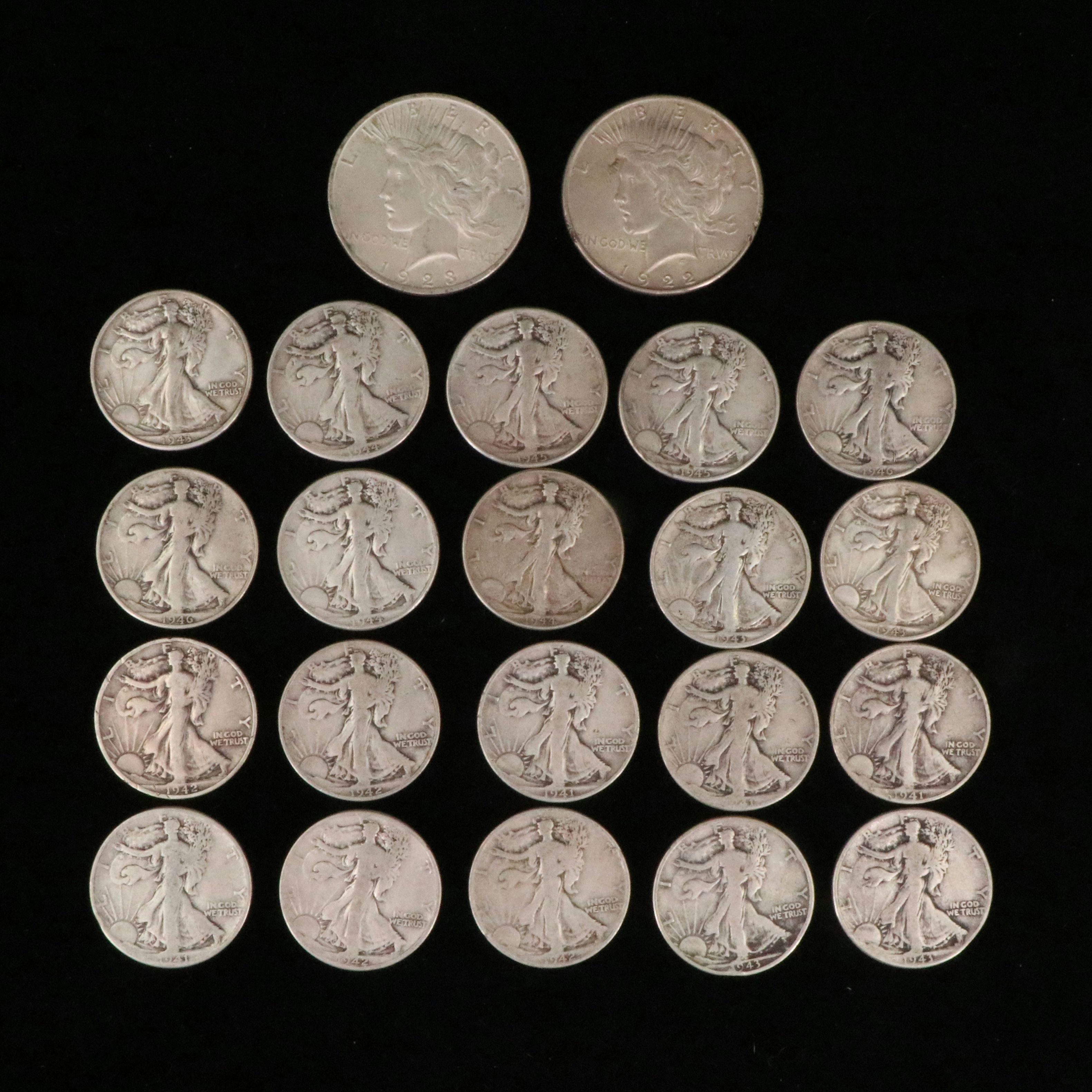 Twenty Walking Liberty half dollars and two Peace dollars