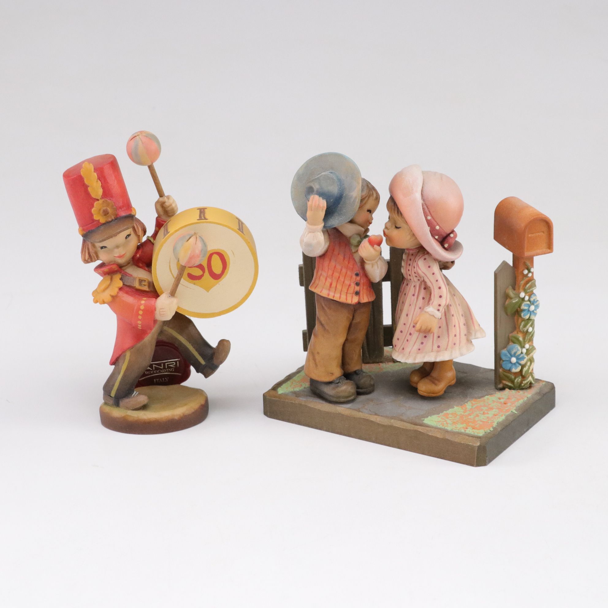 Eleven ANRI Painted Carved Wood Figurines of Children with Two Display Stands