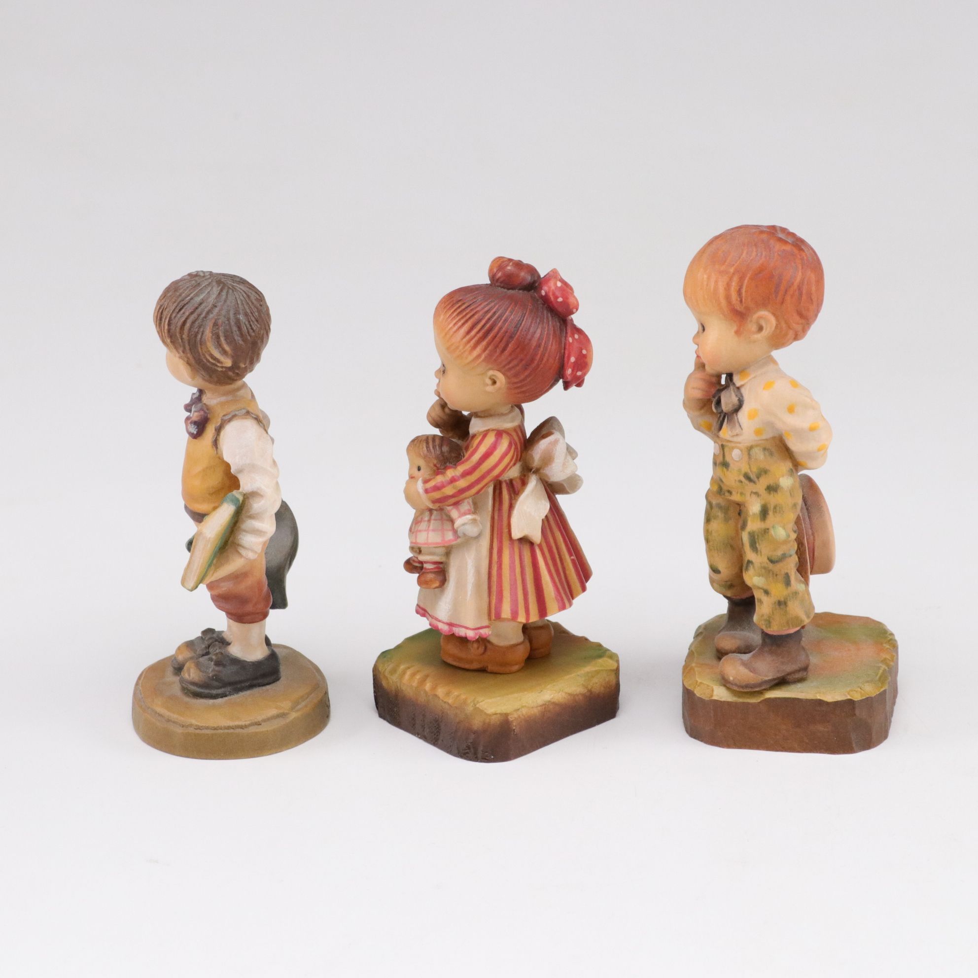 Eleven ANRI Painted Carved Wood Figurines of Children with Two Display Stands
