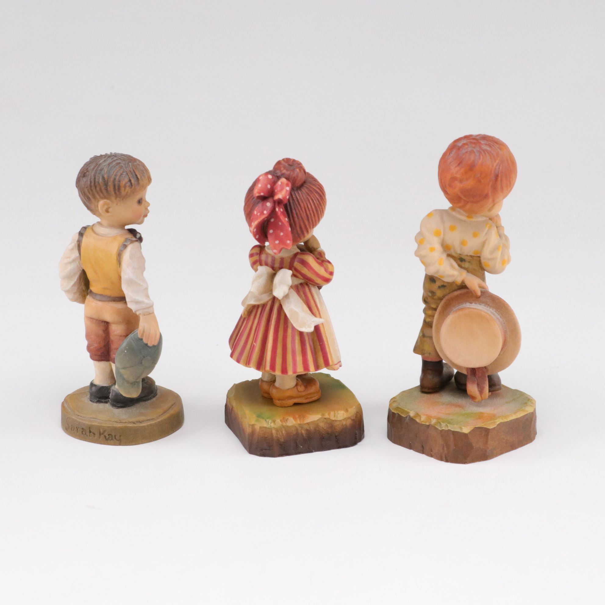 Eleven ANRI Painted Carved Wood Figurines of Children with Two Display Stands