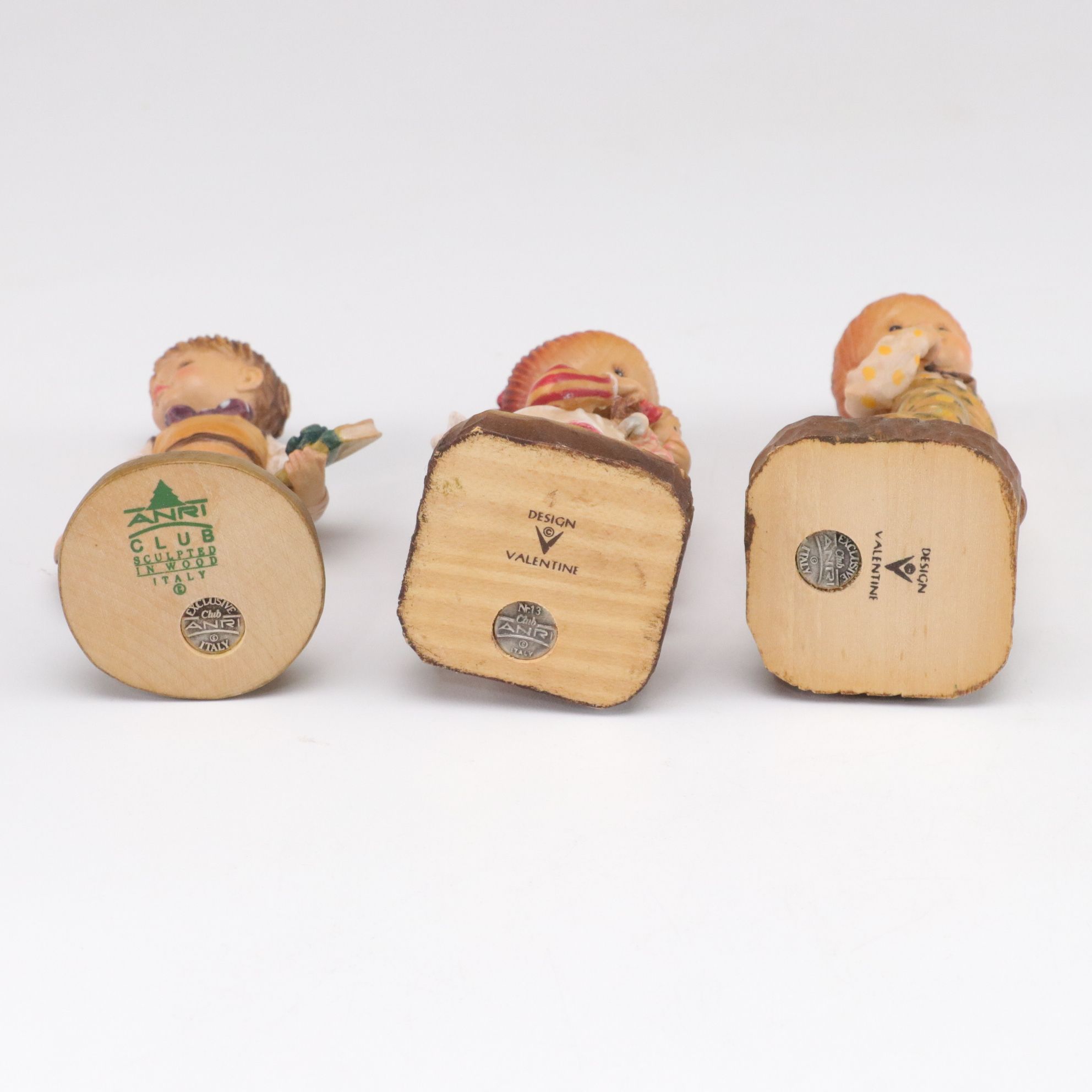 Eleven ANRI Painted Carved Wood Figurines of Children with Two Display Stands