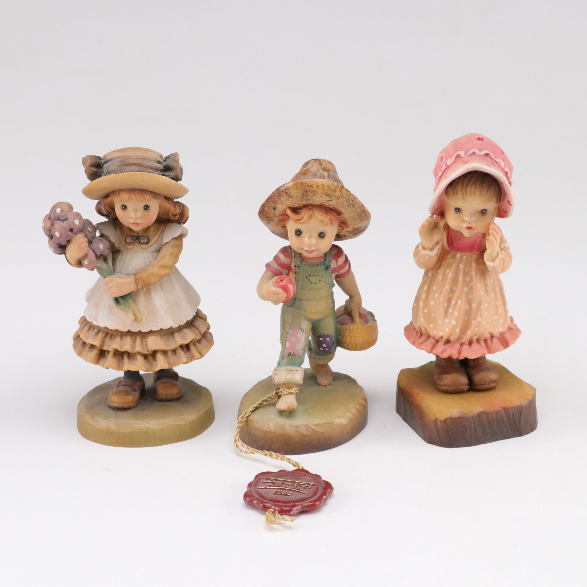 Eleven ANRI Painted Carved Wood Figurines of Children with Two Display Stands