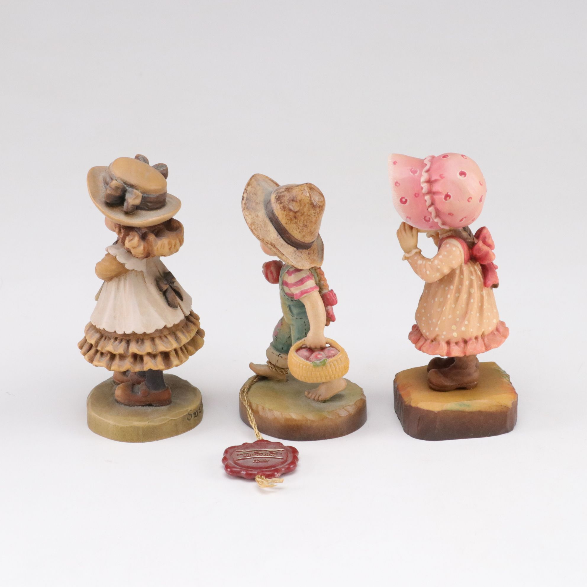 Eleven ANRI Painted Carved Wood Figurines of Children with Two Display Stands