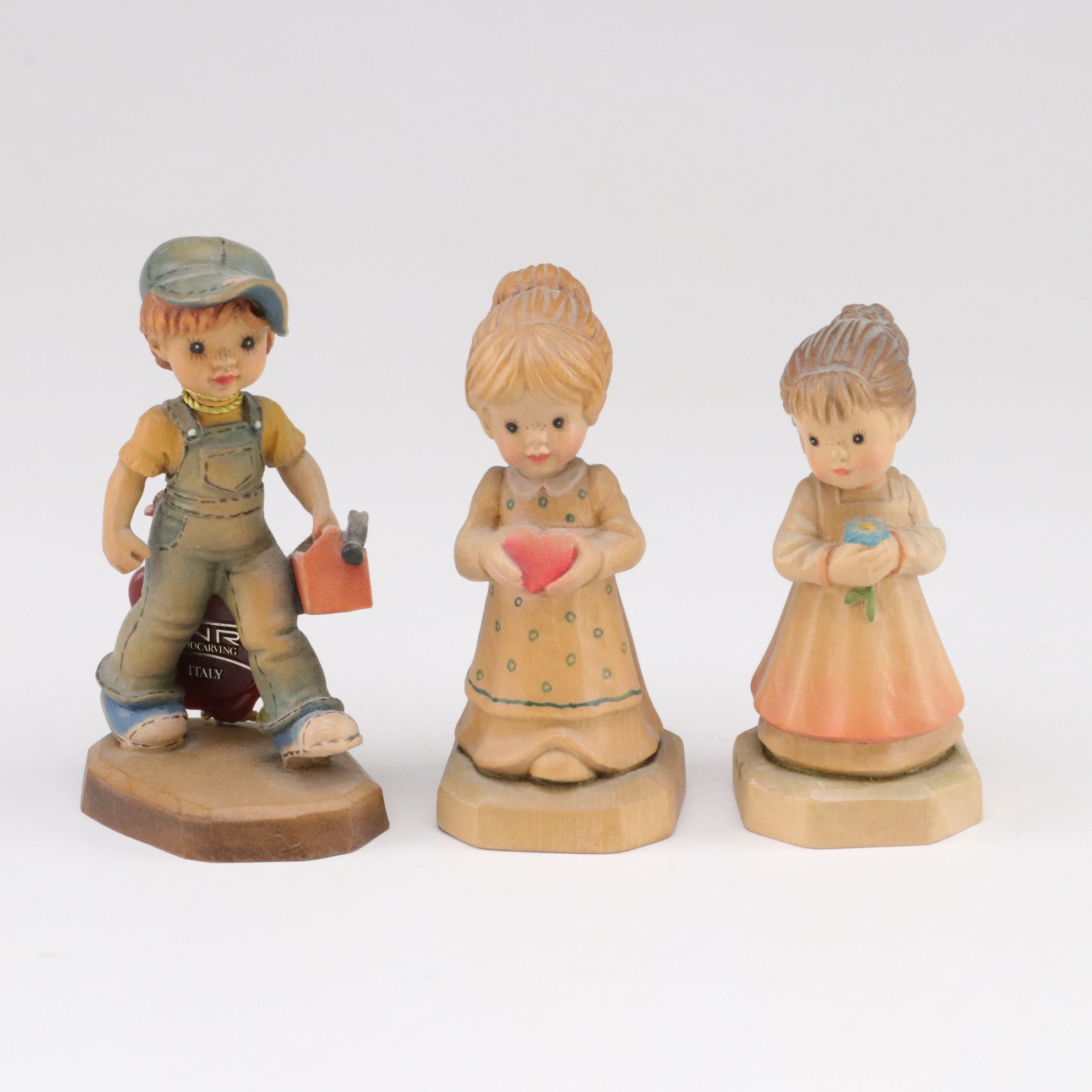 Eleven ANRI Painted Carved Wood Figurines of Children with Two Display Stands