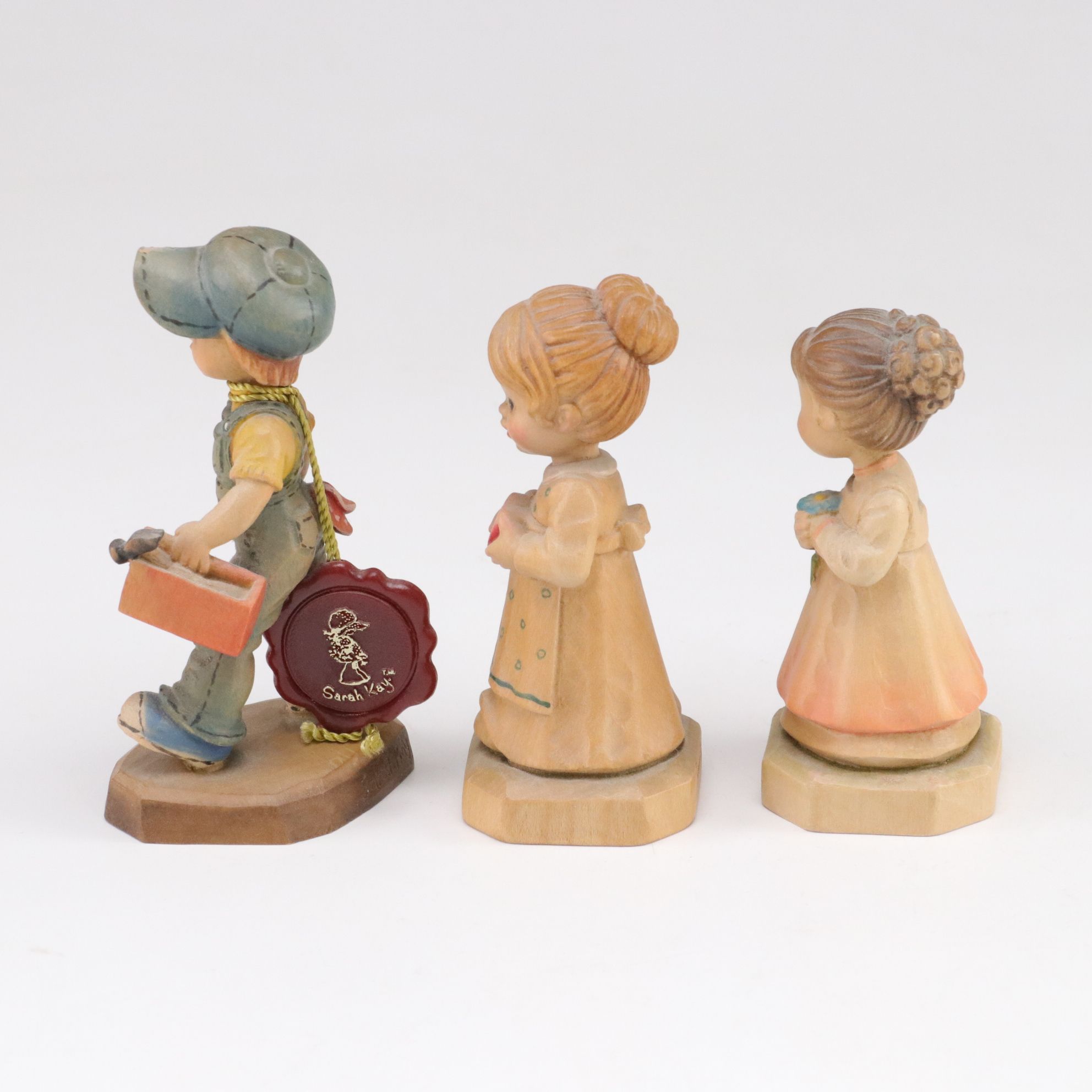 Eleven ANRI Painted Carved Wood Figurines of Children with Two Display Stands