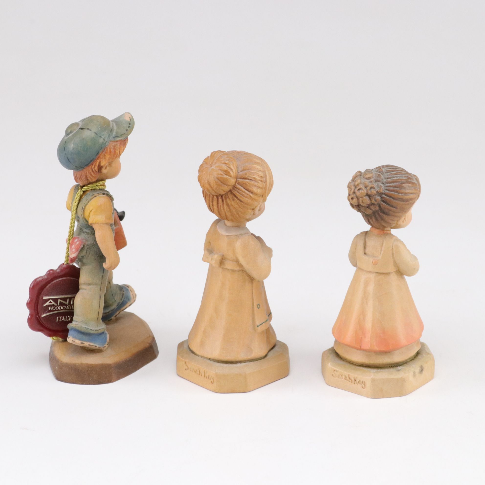 Eleven ANRI Painted Carved Wood Figurines of Children with Two Display Stands
