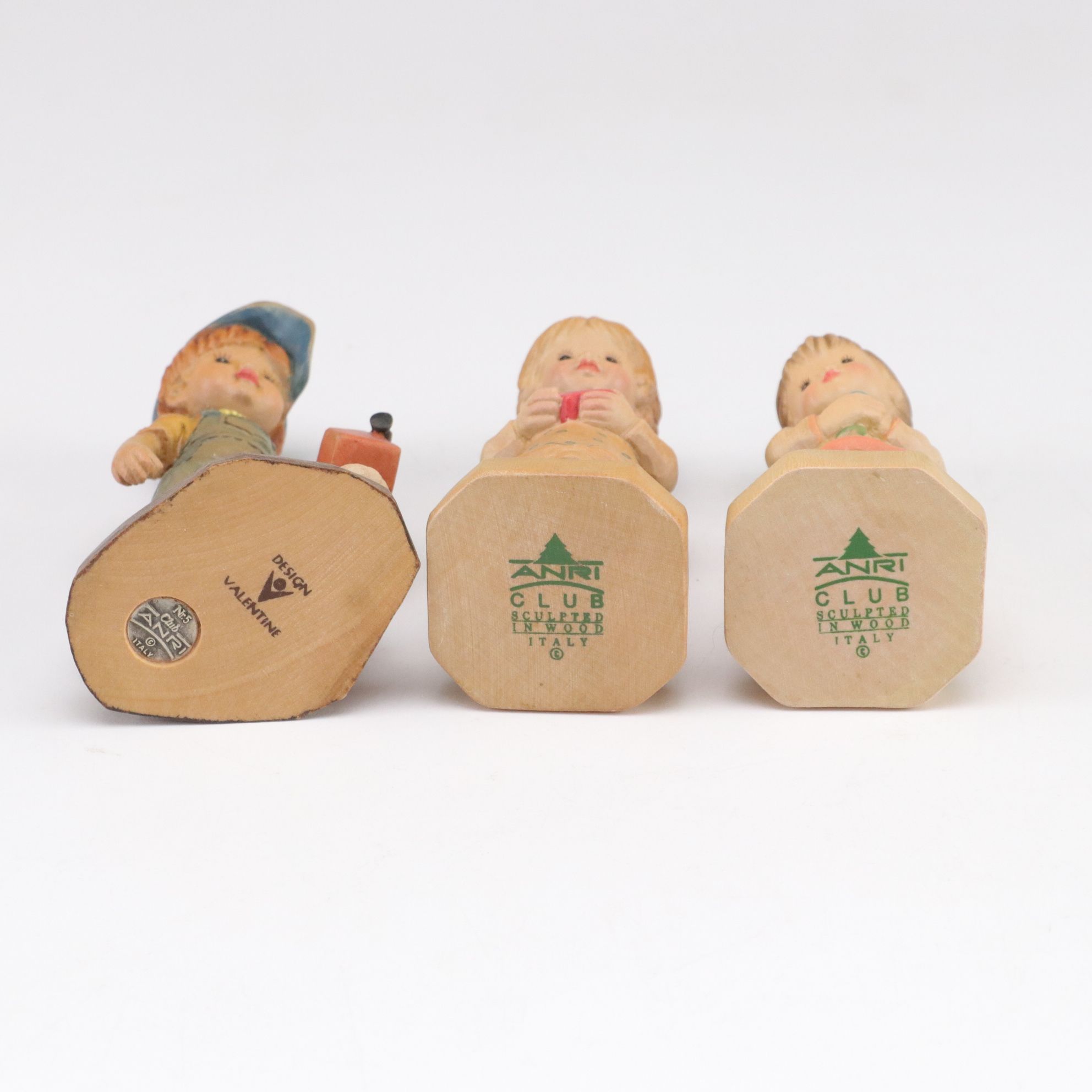 Eleven ANRI Painted Carved Wood Figurines of Children with Two Display Stands