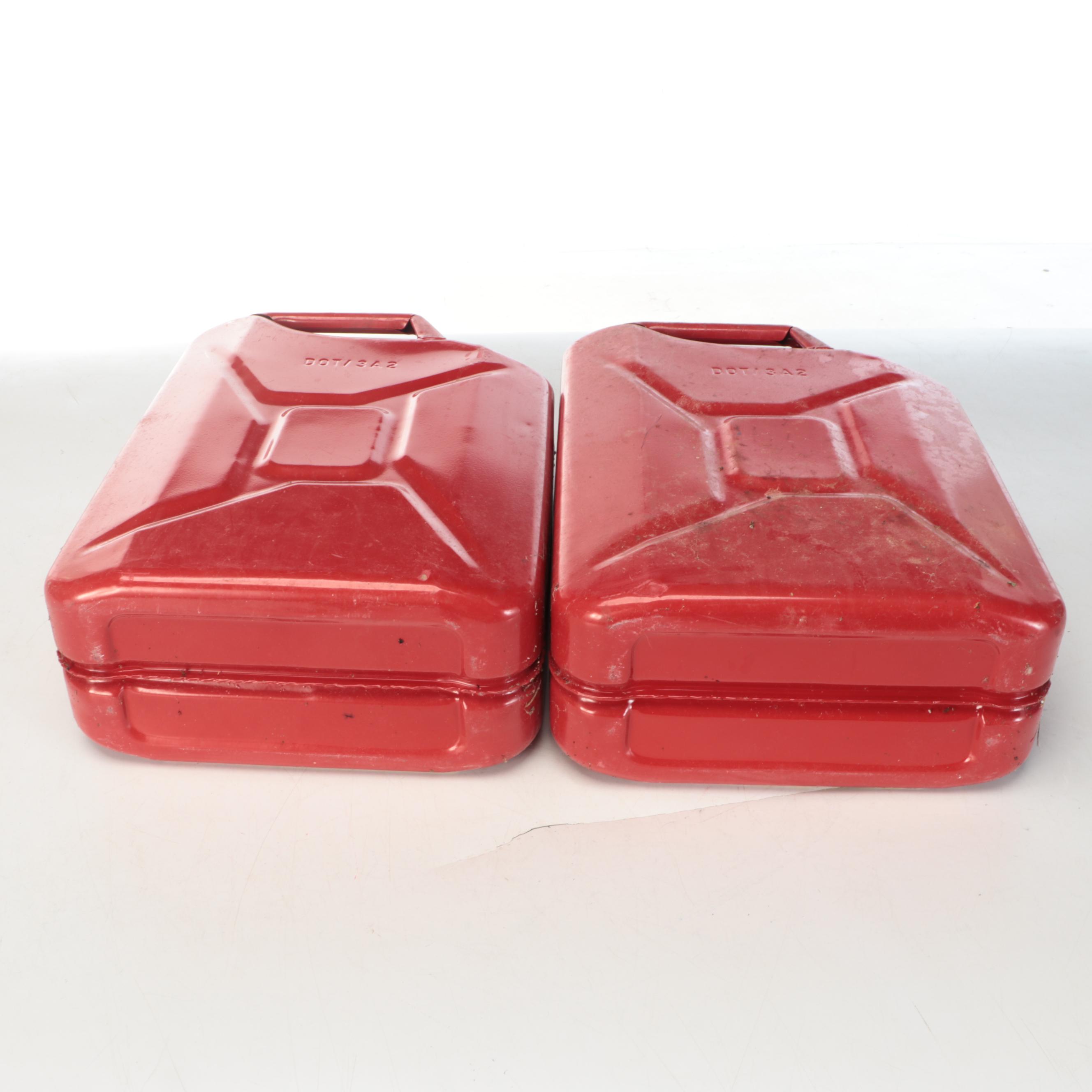 Two Red Metal Gasoline Cans