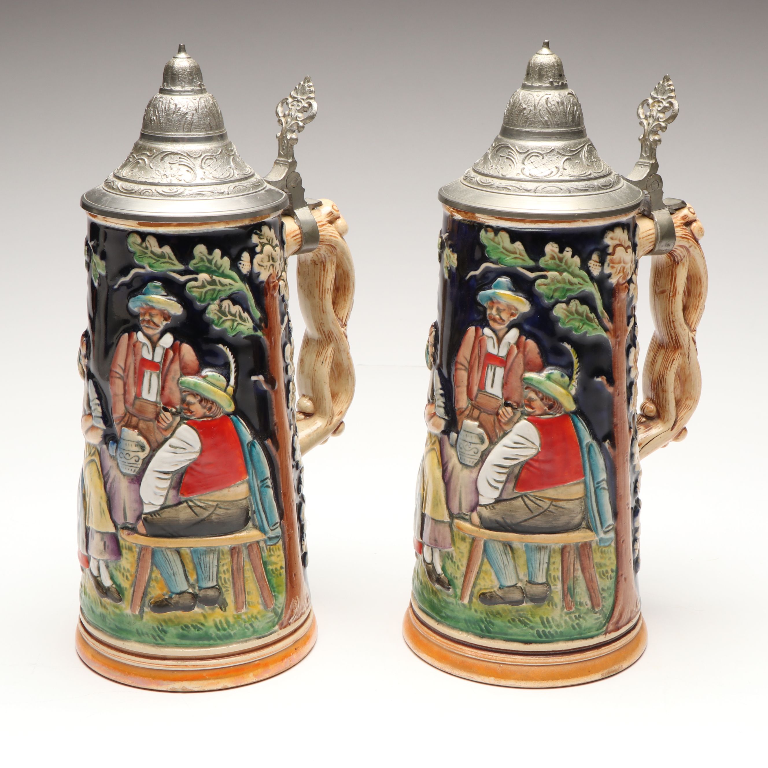 Pair of German Embossed Provincial Scene Steins