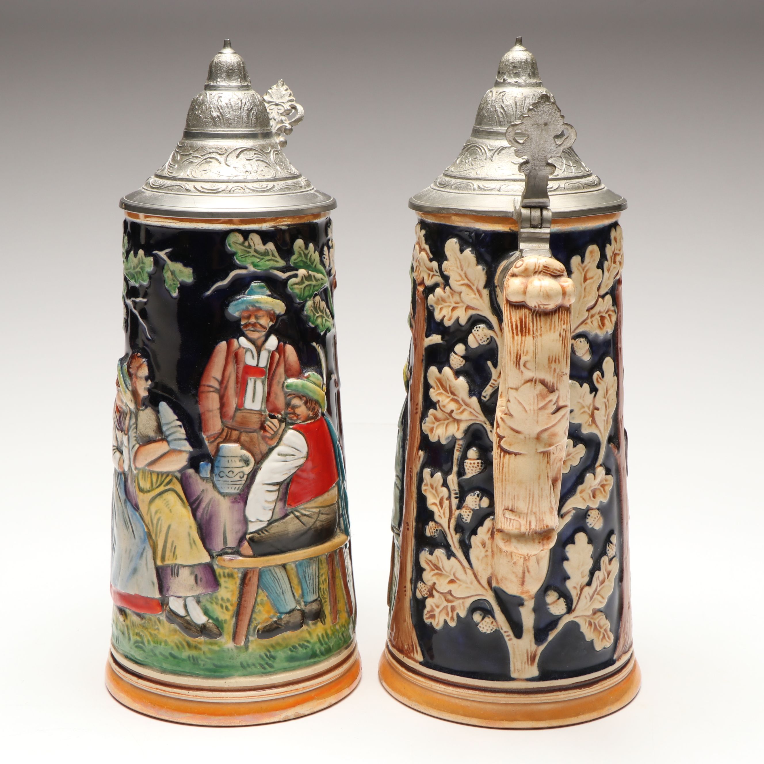 Pair of German Embossed Provincial Scene Steins