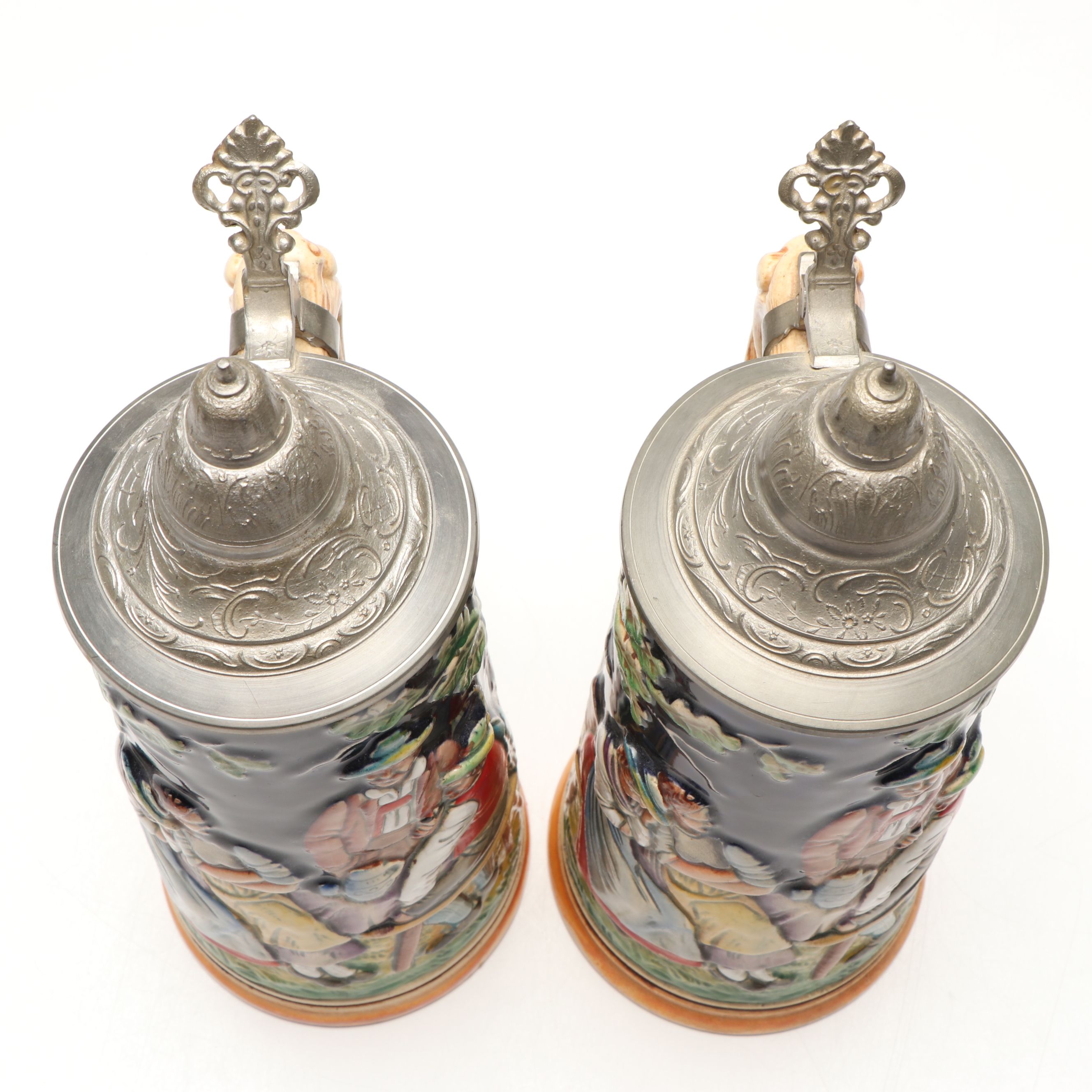 Pair of German Embossed Provincial Scene Steins