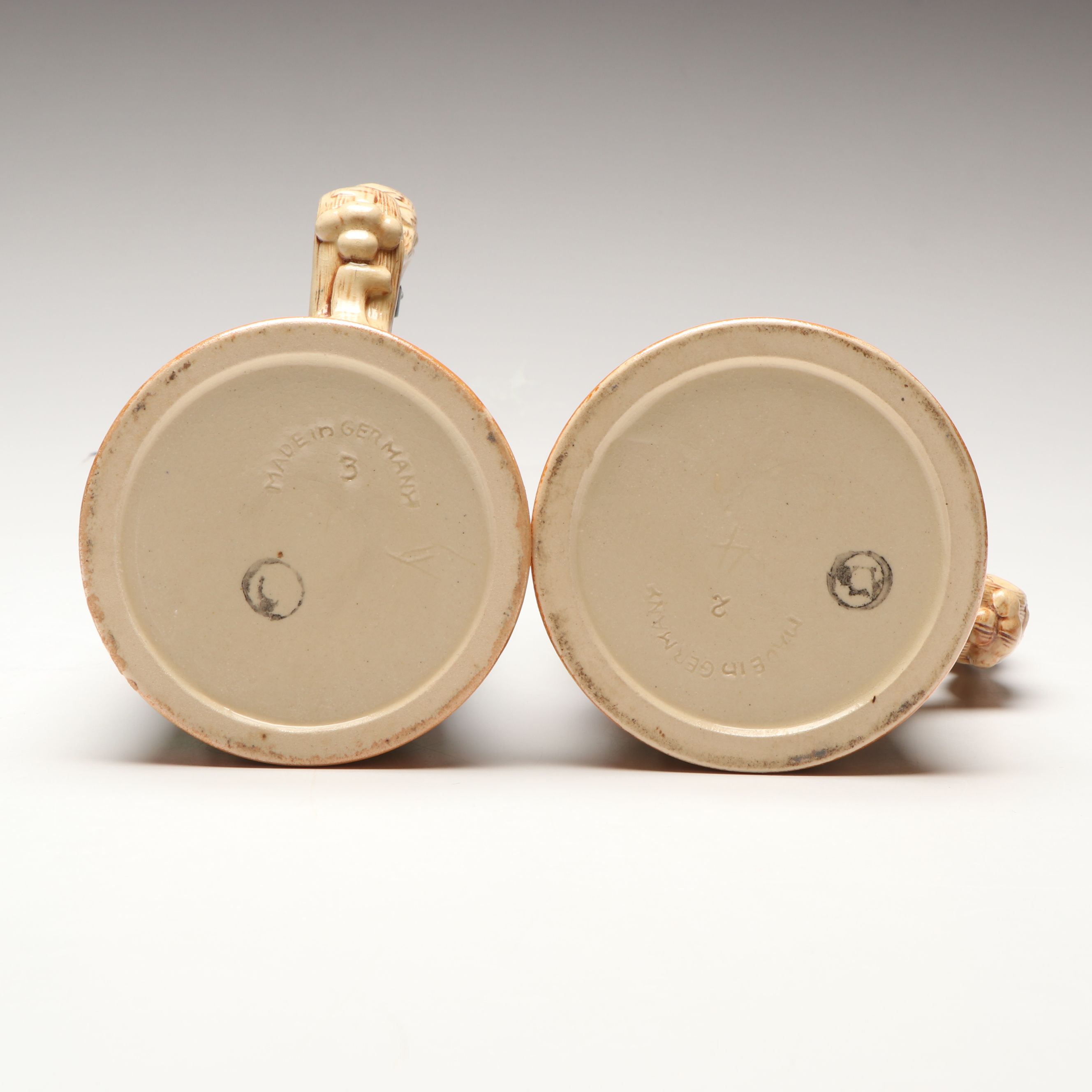 Pair of German Embossed Provincial Scene Steins