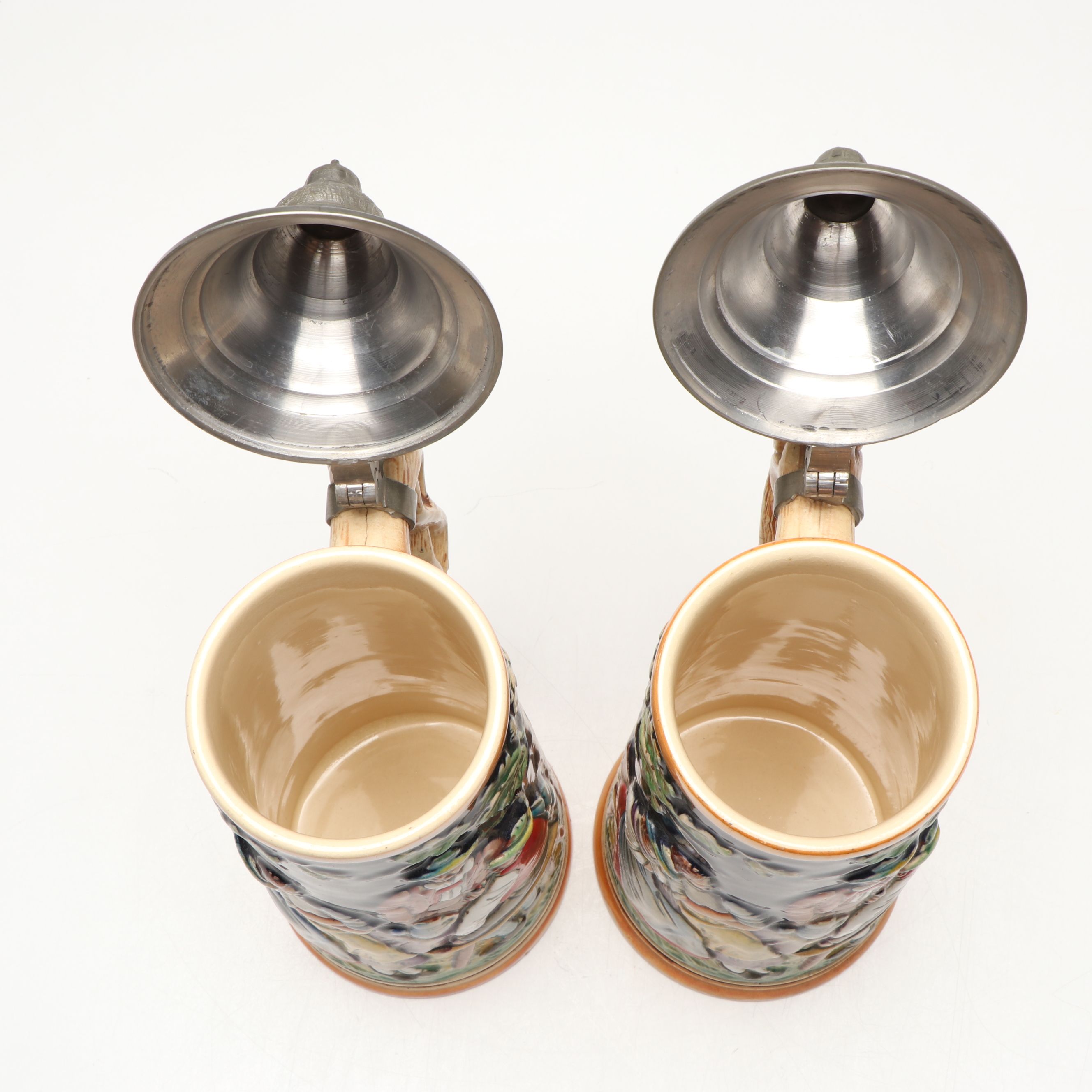 Pair of German Embossed Provincial Scene Steins